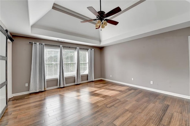 4770 Spring Park Cir, Suwanee, GA 30024 - unfurnished room with a tray ceiling, a ceiling fan, wood finished floors, and a barn door