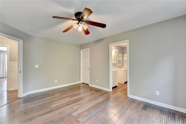 4770 Spring Park Cir, Suwanee, GA 30024 - unfurnished bedroom featuring wood finished floors, connected bathroom, and a ceiling fan