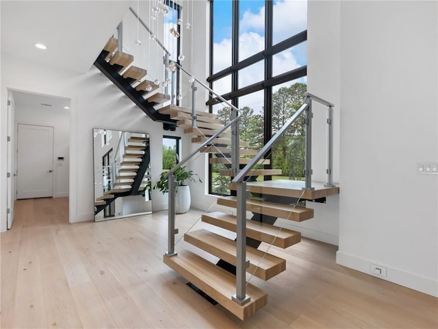 2940 Old Peachtree Rd, Dacula, GA 30019 - stairway featuring a high ceiling, wood finished floors, baseboards, and recessed lighting