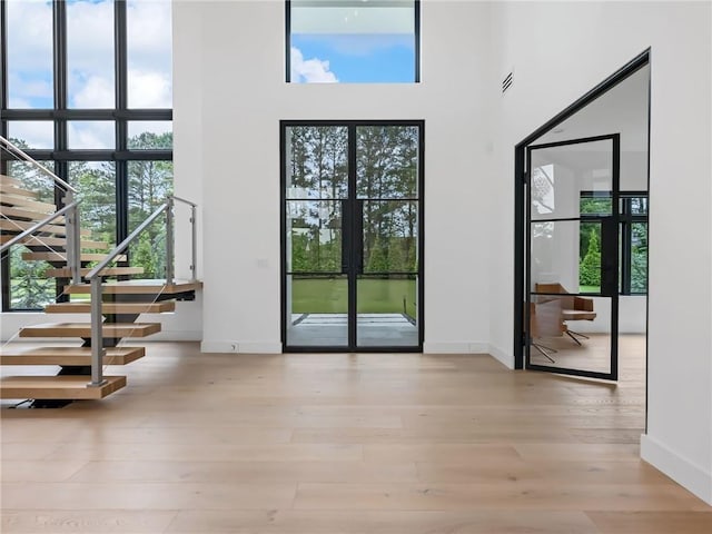 2940 Old Peachtree Rd, Dacula, GA 30019 - doorway featuring a towering ceiling, stairway, wood finished floors, and baseboards