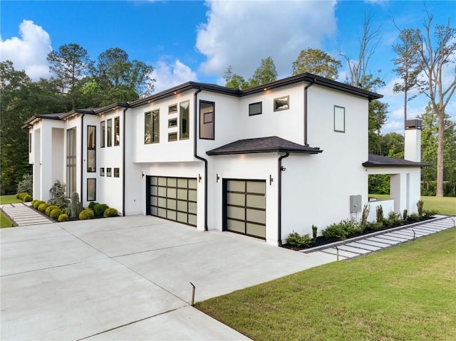 2940 Old Peachtree Rd, Dacula, GA 30019 - modern home with a garage, concrete driveway, a front lawn, stucco siding, and a chimney