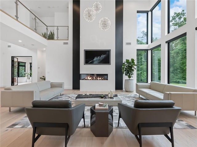 2940 Old Peachtree Rd, Dacula, GA 30019 - living area featuring a high ceiling, a glass covered fireplace, and light wood-type flooring