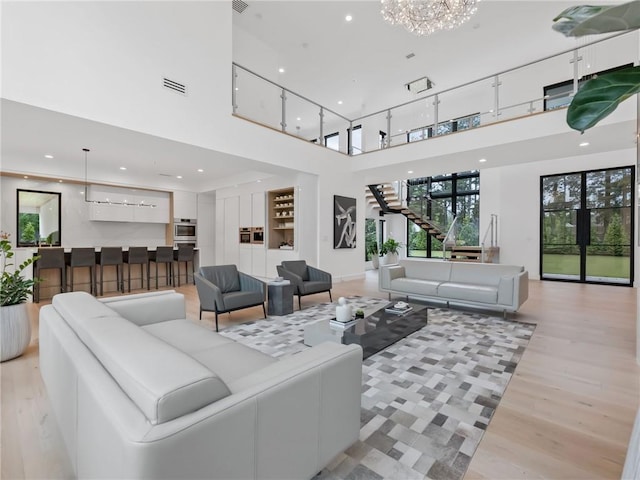 2940 Old Peachtree Rd, Dacula, GA 30019 - living area featuring a towering ceiling, light wood-type flooring, recessed lighting, a chandelier, and stairs