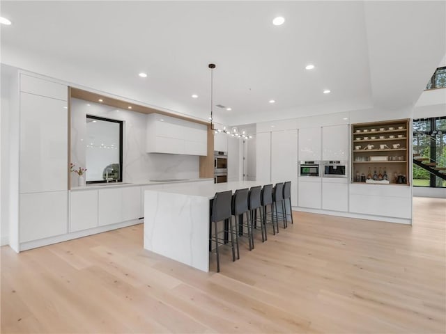 2940 Old Peachtree Rd, Dacula, GA 30019 - kitchen featuring modern cabinets, white cabinets, light wood-type flooring, and recessed lighting