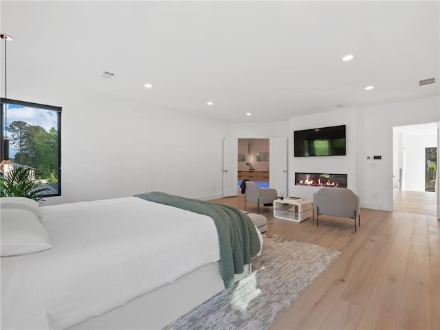 2940 Old Peachtree Rd, Dacula, GA 30019 - bedroom featuring multiple windows, recessed lighting, wood finished floors, a glass covered fireplace, and baseboards