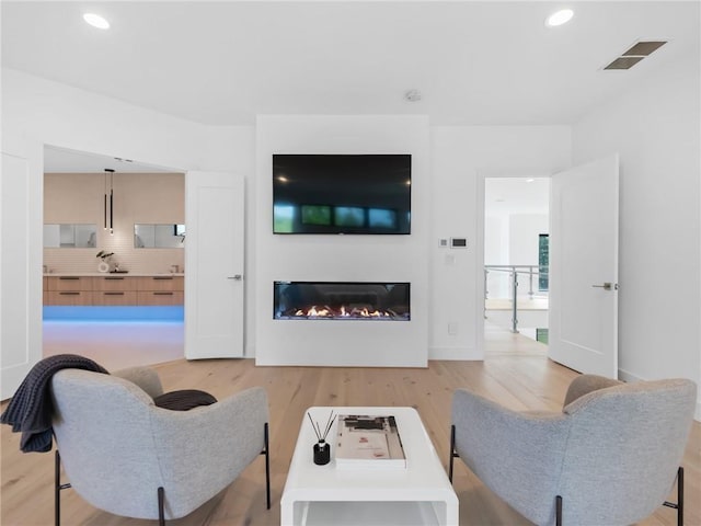 2940 Old Peachtree Rd, Dacula, GA 30019 - living room featuring light wood-style floors, a glass covered fireplace, and recessed lighting