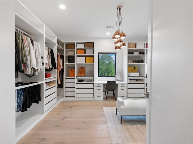 2940 Old Peachtree Rd, Dacula, GA 30019 - spacious closet featuring light wood finished floors, built in desk, and a chandelier