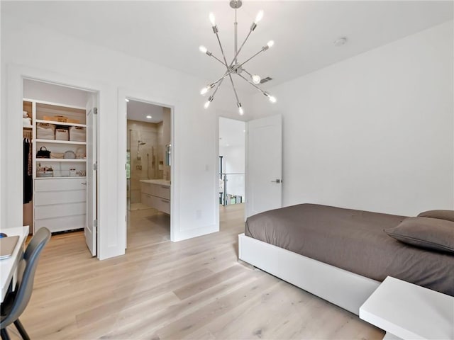 2940 Old Peachtree Rd, Dacula, GA 30019 - bedroom with a chandelier, light wood-style flooring, a spacious closet, and connected bathroom