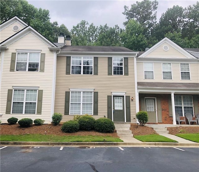 4645 Valais Ct Unit 10, Johns Creek, GA 30022 - view of property with a chimney and uncovered parking