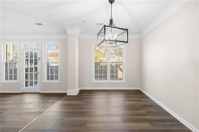 unfurnished dining area with visible vents, baseboards, ornamental molding, a chandelier, and wood finished floors