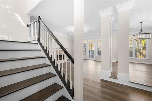 stairway featuring crown molding, baseboards, an inviting chandelier, and wood finished floors