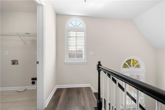 corridor with a wealth of natural light, an upstairs landing, and baseboards