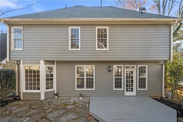 back of house featuring a shingled roof and a wooden deck