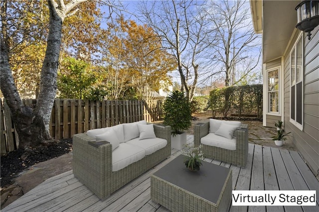 wooden terrace featuring an outdoor living space and a fenced backyard