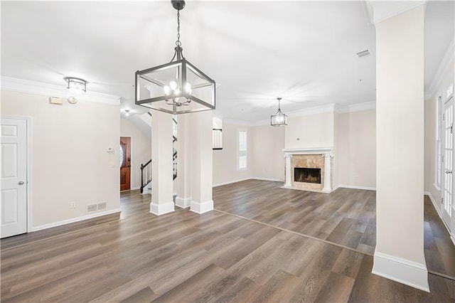 unfurnished living room featuring crown molding, baseboards, and a notable chandelier