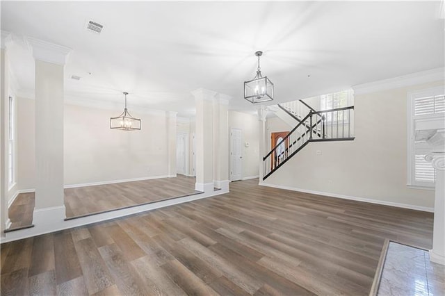 unfurnished living room with wood finished floors, a notable chandelier, visible vents, and stairway