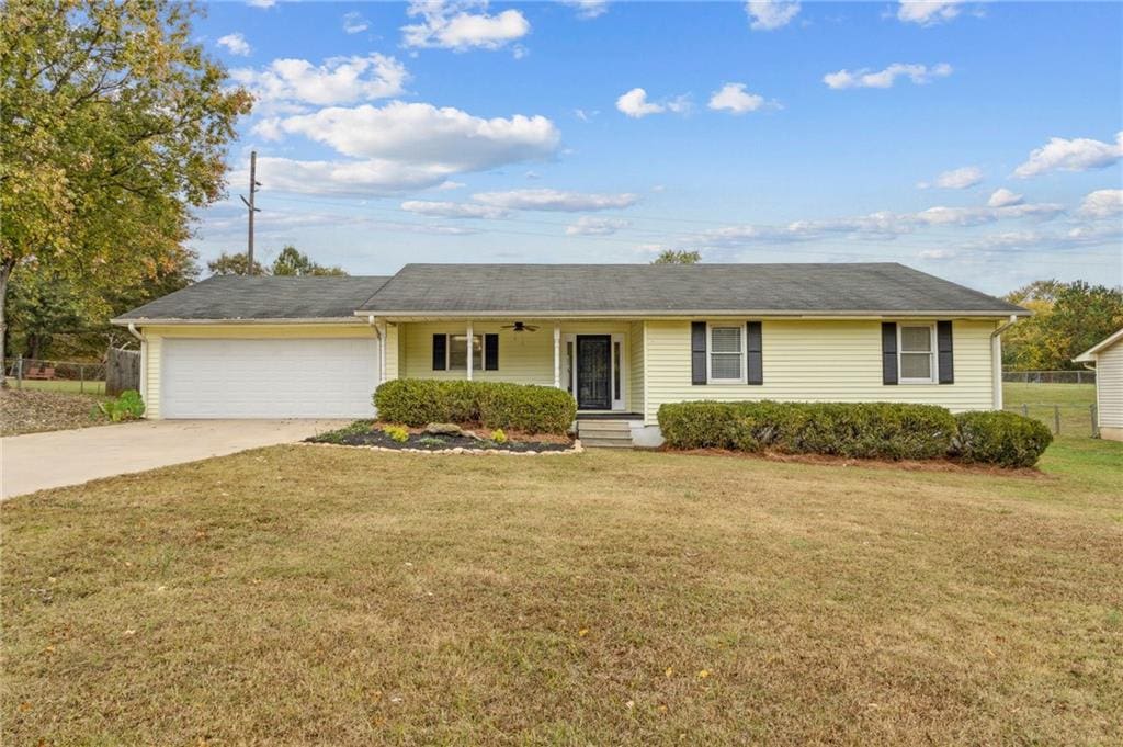 ranch-style home featuring a garage and a front lawn