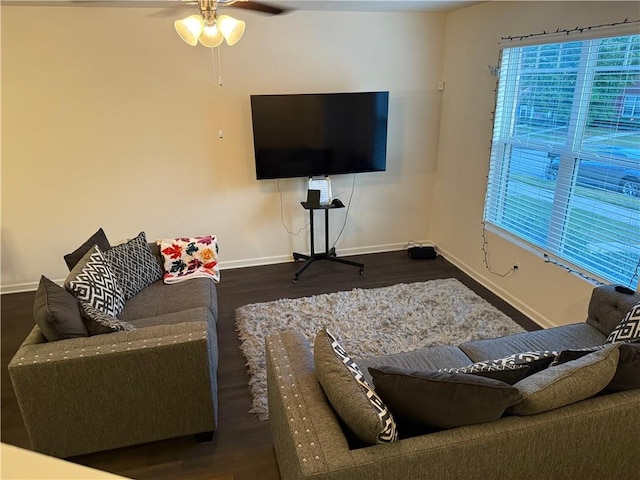 living room featuring dark wood-type flooring and ceiling fan