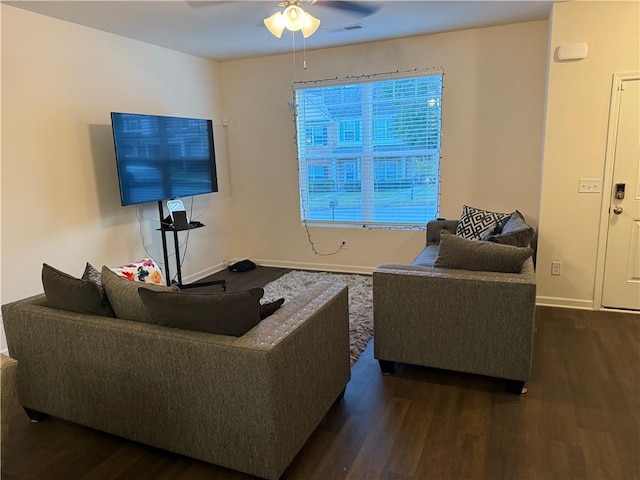 living room featuring dark wood-type flooring and ceiling fan