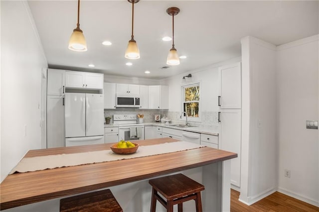 kitchen with white appliances, sink, and white cabinets