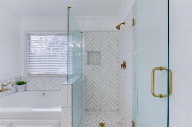 bathroom with ornamental molding and shower with separate bathtub