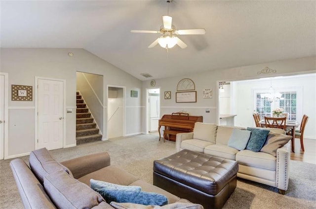 living room featuring vaulted ceiling, carpet flooring, and ceiling fan with notable chandelier