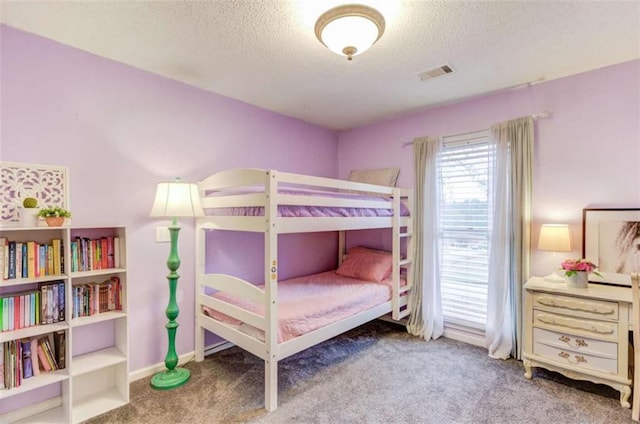 bedroom featuring carpet floors and a textured ceiling