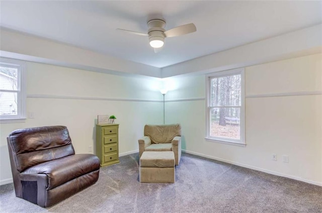 living area featuring carpet floors and ceiling fan