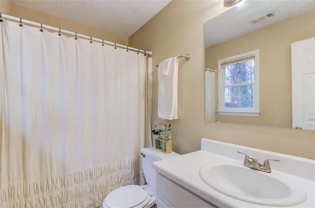 bathroom featuring vanity, a textured ceiling, and toilet