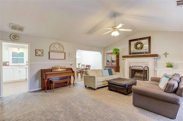 carpeted living room with lofted ceiling and ceiling fan