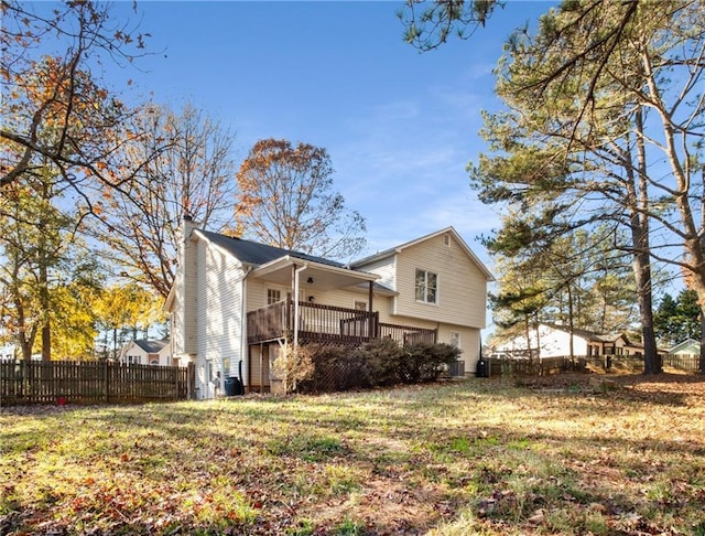 rear view of property featuring a yard and a deck