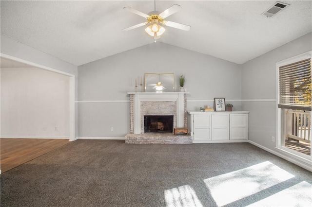 unfurnished living room featuring ceiling fan, carpet floors, a fireplace, and vaulted ceiling