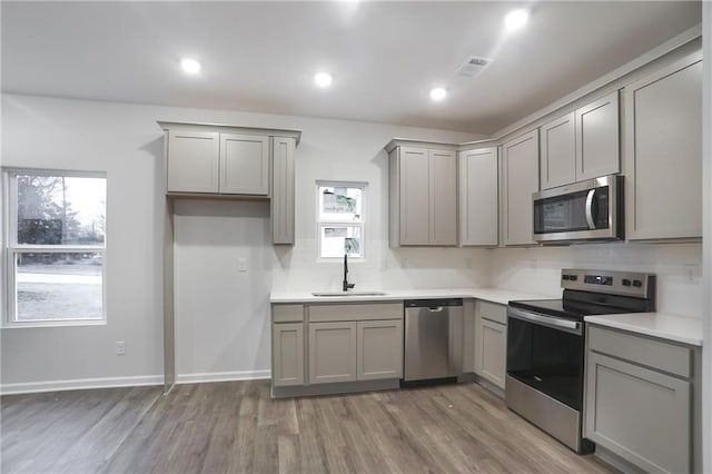 1005 Sims Ave NW, Atlanta, GA 30318 - kitchen with gray cabinets, a sink, tasteful backsplash, appliances with stainless steel finishes, and visible vents