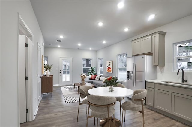 1005 Sims Ave NW, Atlanta, GA 30318 - kitchen with gray cabinetry, a sink, fridge with ice dispenser, and light wood-type flooring