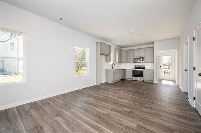 1005 Sims Ave NW, Atlanta, GA 30318 - unfurnished living room with baseboards, visible vents, dark wood-style floors, and a sink