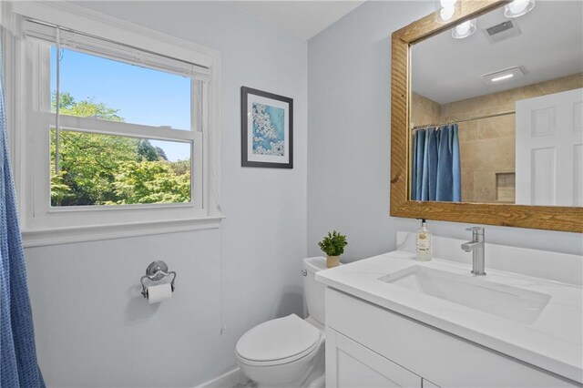 bathroom featuring toilet, a shower with shower curtain, and vanity