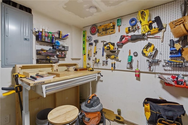 misc room with a workshop area and electric panel