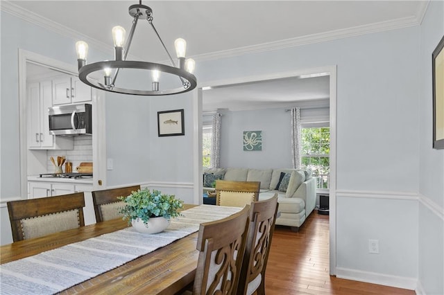 dining room featuring a chandelier, wood finished floors, and ornamental molding