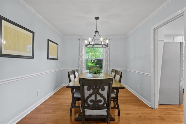 dining area with a chandelier, light wood-type flooring, baseboards, and ornamental molding