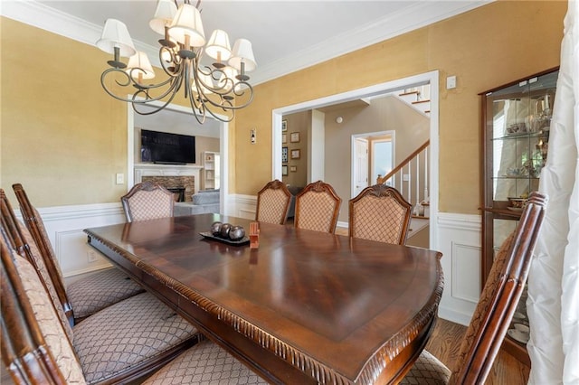 dining space featuring ornamental molding, wainscoting, and a chandelier
