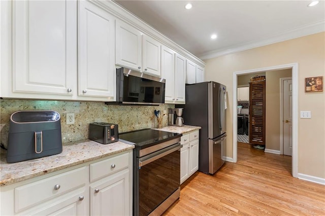 kitchen with tasteful backsplash, stainless steel appliances, white cabinetry, light wood-type flooring, and ornamental molding