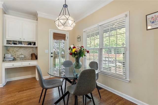 dining area featuring baseboards, ornamental molding, and wood finished floors