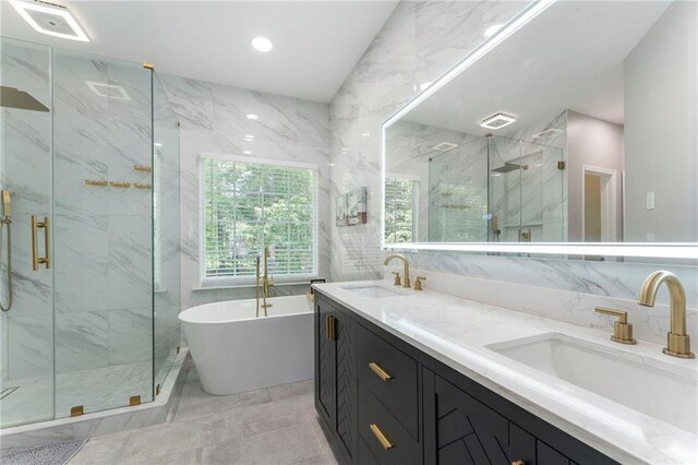 full bath with tile walls, a marble finish shower, and a sink