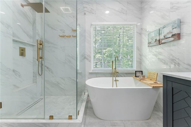 bathroom with a freestanding tub, tile walls, vanity, tile patterned floors, and a marble finish shower