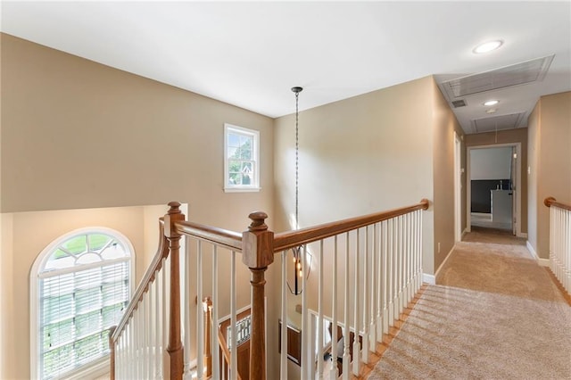 hallway with a healthy amount of sunlight, attic access, and an upstairs landing