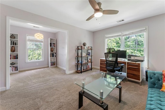carpeted home office with baseboards, a ceiling fan, and visible vents