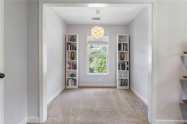 spare room featuring visible vents, carpet flooring, and baseboards
