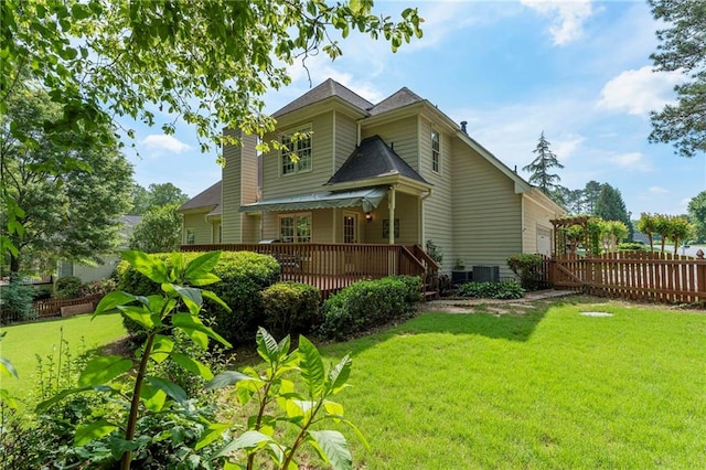 rear view of property featuring a lawn, fence, a porch, and cooling unit