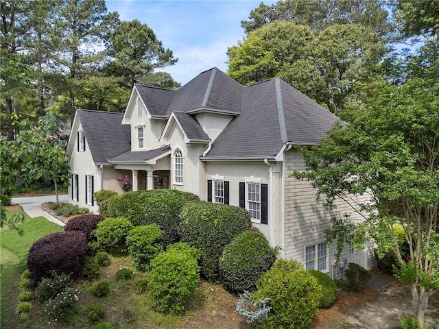 view of home's exterior with roof with shingles and stucco siding