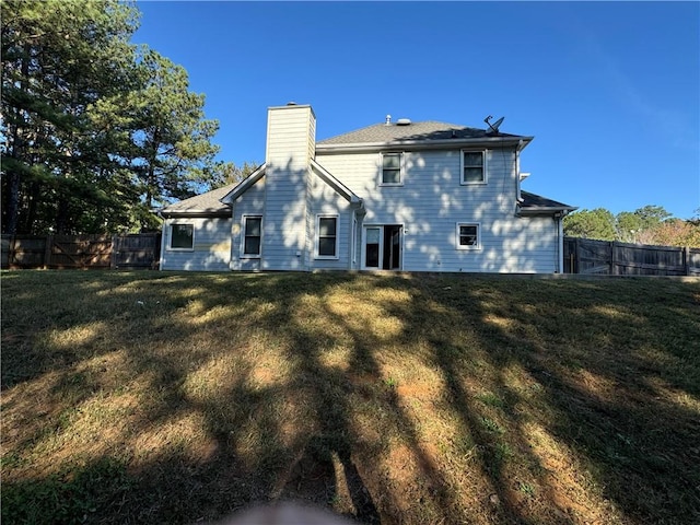 rear view of house featuring a lawn